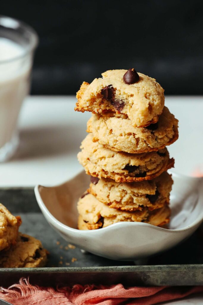 Soft and chewy vegan gluten-free chocolate chip cookies on a parchment-lined baking sheet