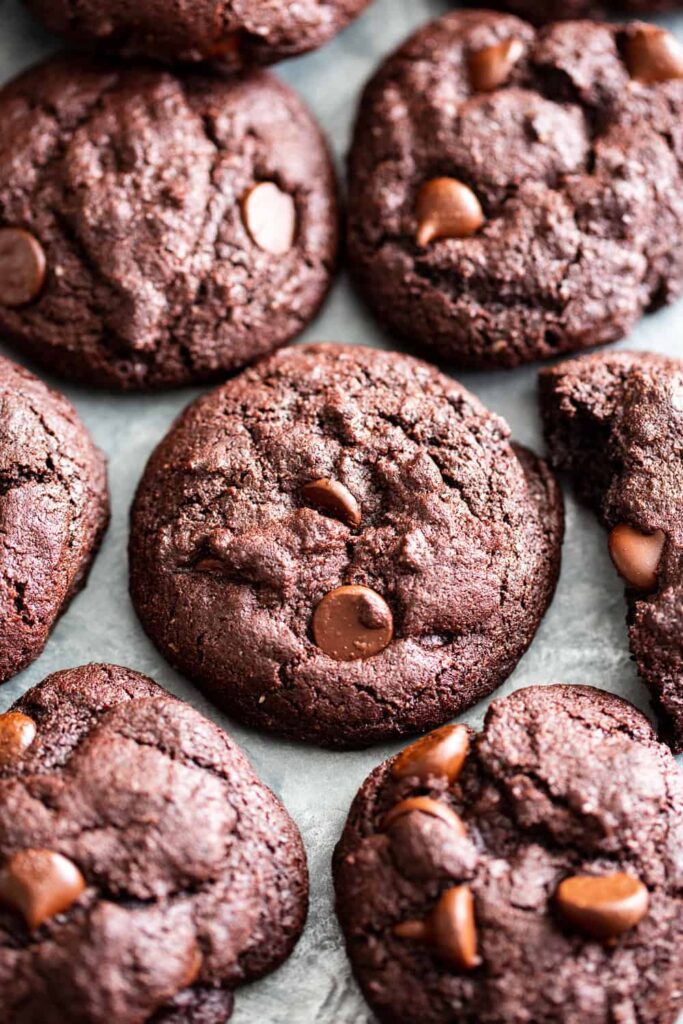 Chewy paleo double chocolate brownie cookies — grain-free, gluten-free and dairy-free — stacked on a wooden board